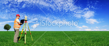 Photo of a SurveyWA surveyor with theodolite in a green field with cloudy blue sky